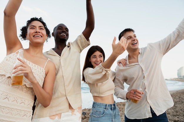 Amici sorridenti a tiro medio in spiaggia