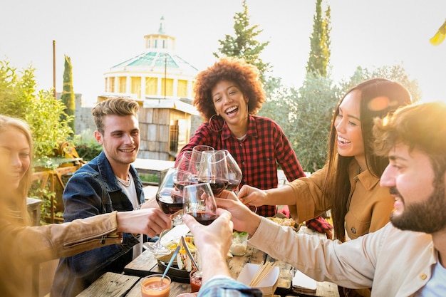 Amici sorridenti che brindano ai drink sul tavolo.