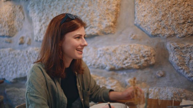 Amici sorridenti che chiacchierano al caffè sotto la luce della lampada da vicino ragazze amichevoli