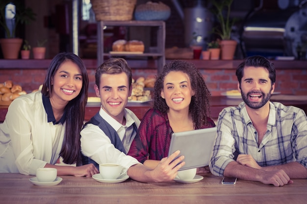 Amici sorridenti tenendo una tavoletta digitale