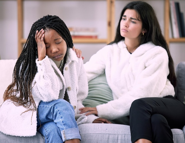 Amici tristi ed empatia con le donne sul divano nel soggiorno per confortare dolore e depressione Salute mentale supporto emotivo e cura con la ragazza che consola a casa per consigli di solidarietà e preoccupazioni