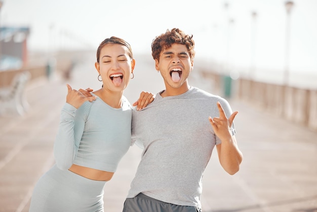 Amici uomo e donna con la lingua fuori felici e pazzi insieme in città dopo l'allenamento fitness all'aperto nella soleggiata estate Divertenti fumetti e giovani asiatici giapponesi sorridono abbraccio e amore per l'amicizia