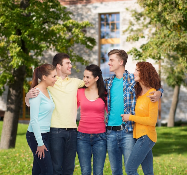 amicizia, istruzione, vacanze estive e concetto di persone - gruppo di adolescenti sorridenti in piedi e abbracciati sullo sfondo del campus