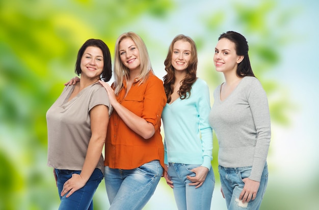 amicizia, moda, corpo positivo, diverso e concetto di persone - gruppo di donne felici di diverse dimensioni in abiti casual su sfondo verde naturale