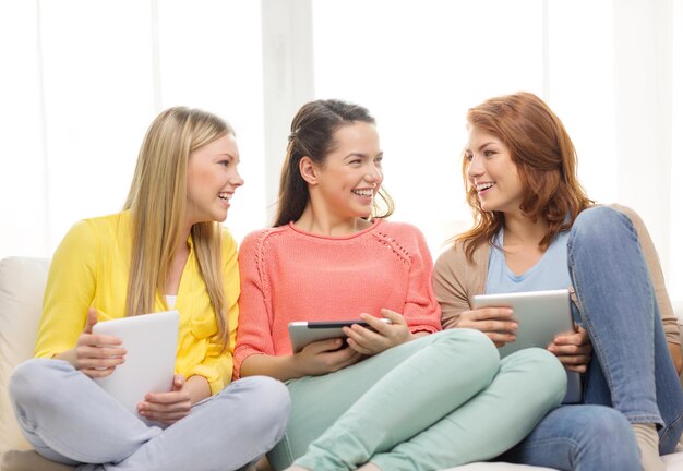 amicizia, tecnologia e concetto di internet - tre ragazze adolescenti sorridenti con computer tablet pc a casa