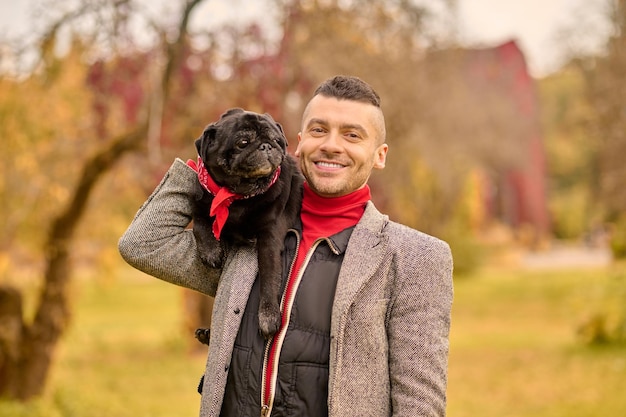 Amicizia. Un uomo sorridente felice con il suo cane nel parco