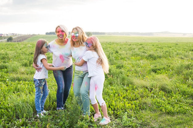 Amicizia, vacanze indiane e concetto di persone - giovani donne e bambini che ballano sul campo estivo sul festival di holi.