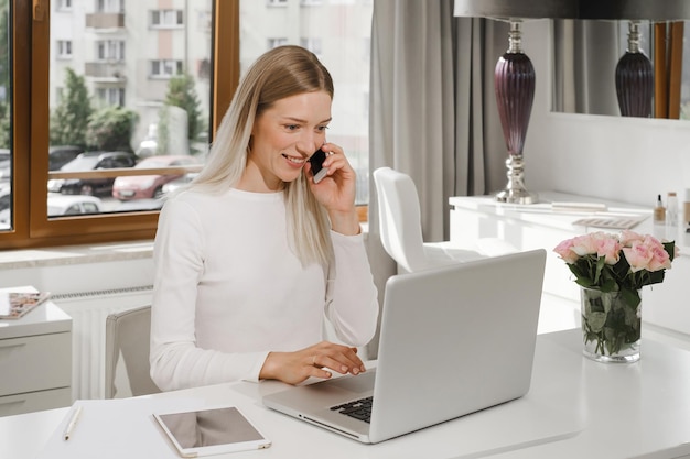 Amministratore donna alla reception che parla con il cliente al telefono per prendere appuntamento