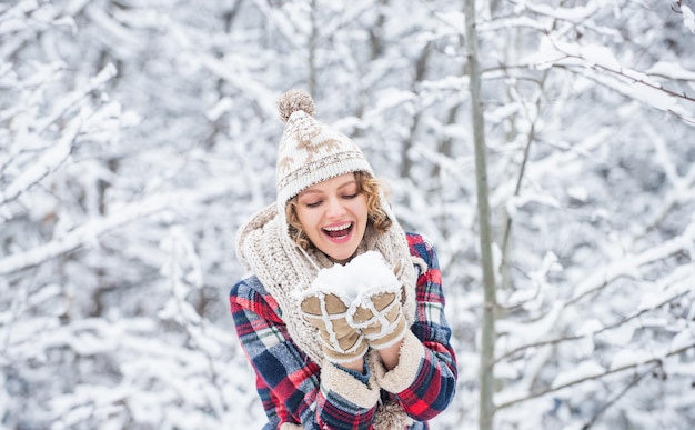 Ammiratore invernale Stagione preferita Passeggiata nella foresta innevata Ragazza felice che si diverte all'aria aperta Periodo natalizio Vestito invernale La donna indossa accessori caldi nella natura innevata Collezione di moda invernale