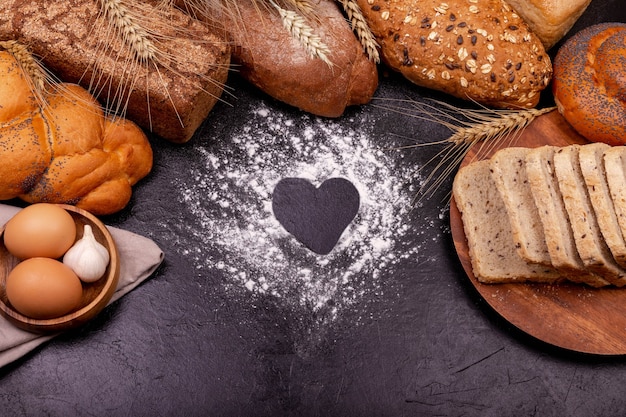 Amo cucinare. Vari di pane di segale su uno sfondo scuro. Copia spazio.