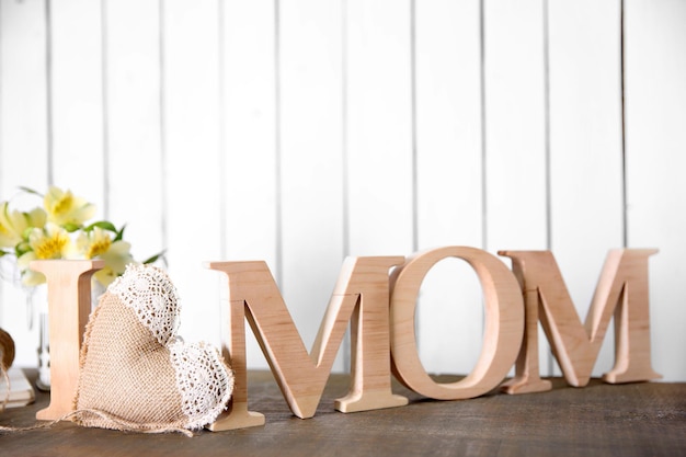 Amo l'iscrizione di mamma di lettere di legno con cuore sul fondo bianco della parete