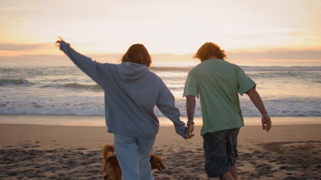 Amore adolescenti in corsa spiaggia sabbiosa sera vista indietro coppia spensierata godersi