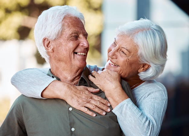 Amore coppia anziana e abbraccio per la felicità pensionamento e legame insieme all'aperto Romantico vecchio e donna anziana abbracciano sorriso e amore per la relazione anniversario e benessere per rilassarsi