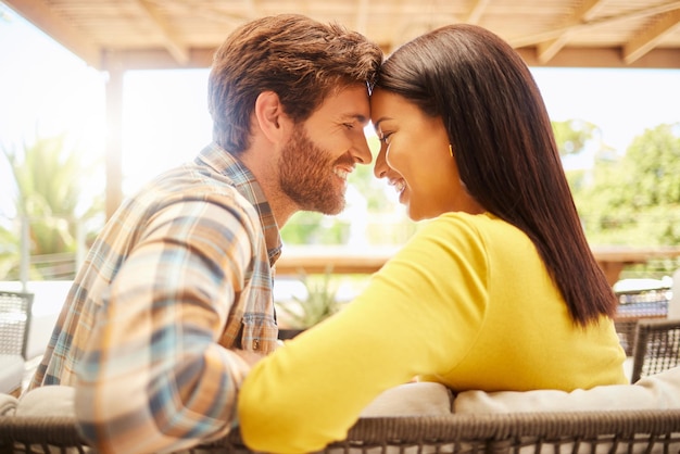 Amore coppia felice rilassarsi su un patio in una nuova casa o casa nel fine settimana Giovane uomo e donna sposati che si legano il giorno di San Valentino o l'anniversario di matrimonio con uno sguardo intimo prima di un bacio