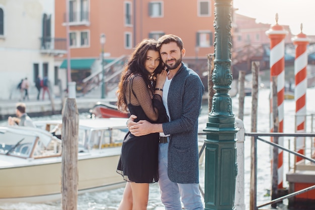 Amore - coppia romantica a Venezia sul molo. Giovani coppie sulle vacanze di vacanza di viaggio che abbracciano