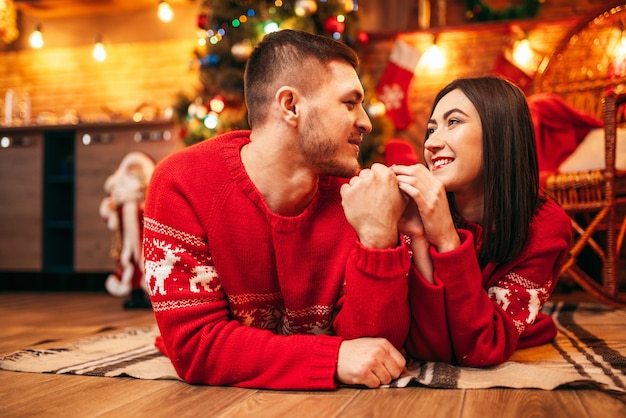 Amore coppia si trova sul pavimento, vacanze di Natale