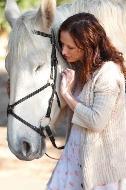 Amore dell'avventura e giovane donna con il suo cavallo in una fattoria all'aperto per corse sportive Allenamento al sorriso e persona femminile sicura del Canada con il suo animale equestre o animale domestico in un ranch di campagna