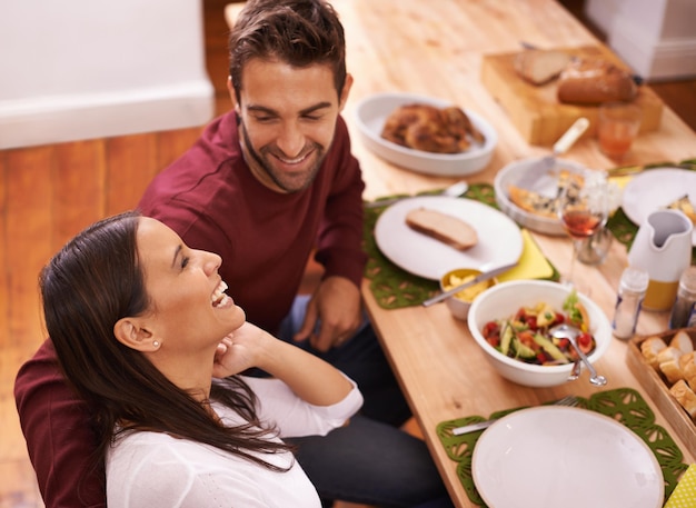 Amore e cibo due delle cose migliori della vita Una coppia felice che si gode un pasto in famiglia attorno al tavolo