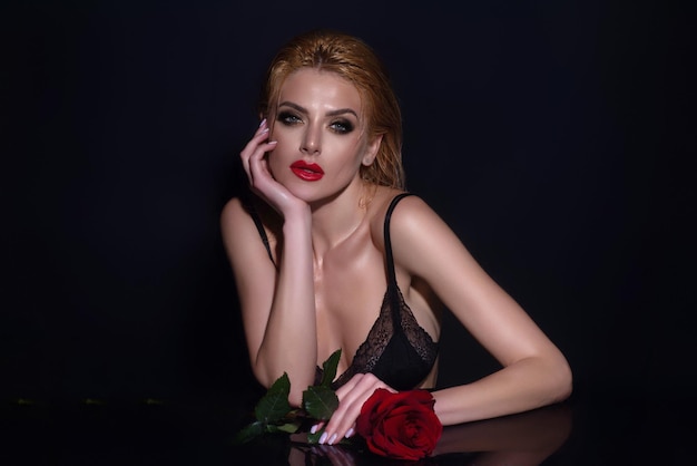 Amore e incontri donna sexy con rosa rossa ritratto in studio di bellezza bellissimo modello con fiore rosa rossa