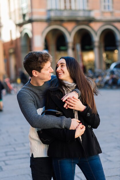 Amore, viaggi, turismo, relazioni e concetto di incontri - romantiche coppie felici che abbracciano in strada. Vacanze di San Valentino