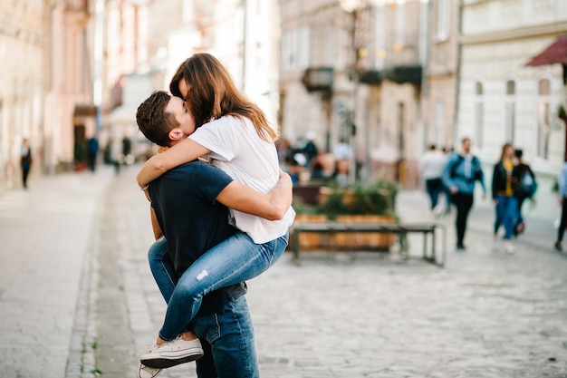 Amorevole coppia felice ragazzo bacia ragazza Un uomo e una donna che camminano lungo le strade della città