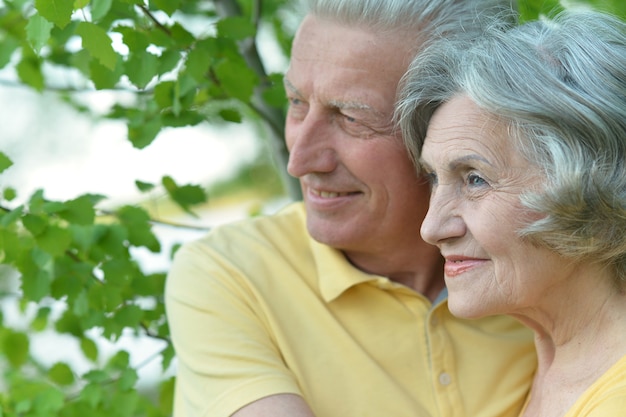 Amorevole coppia senior su uno sfondo di alberi in estate