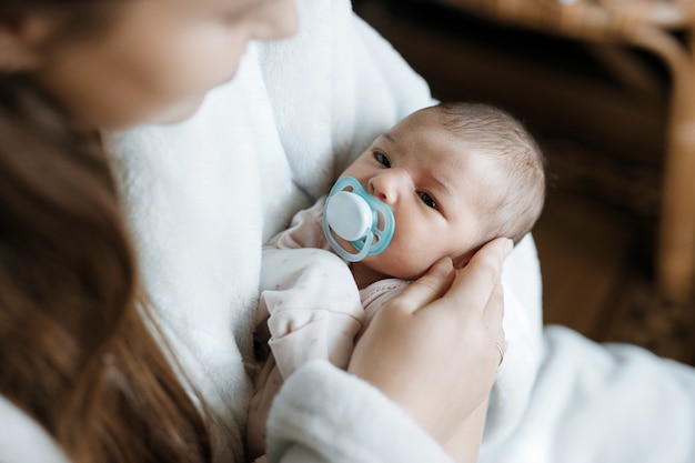 amorevole mamma che si prende cura del suo neonato a casa