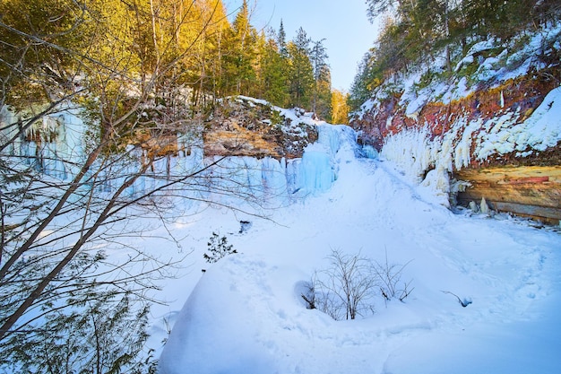 Ampia vista della grande cascata ghiacciata in inverno sulle scogliere