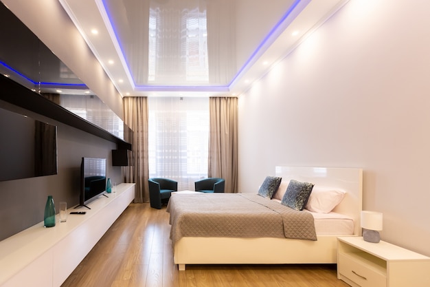 ampio soggiorno con letto, mobili e tv in stile moderno