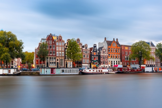 Amsterdam canal Amstel con tipiche case olandesi e houseboat dalla barca al mattino, Olanda, Paesi Bassi.