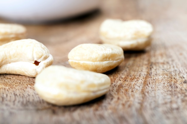 Anacardi croccanti, anacardi crudi deliziosi e sani, primo piano di anacardi sbucciati sul tavolo della cucina