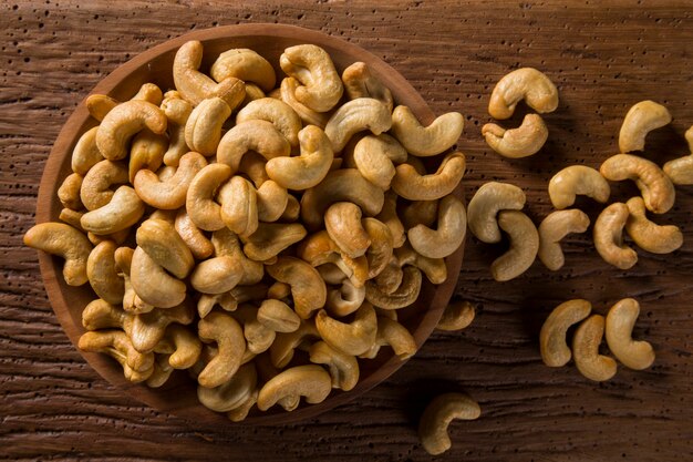 Anacardi in ciotola di legno su uno sfondo di legno