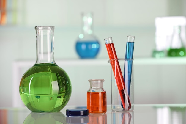 Analisi di laboratorio Diversi vasi di vetro con liquidi su tavolo bianco al chiuso