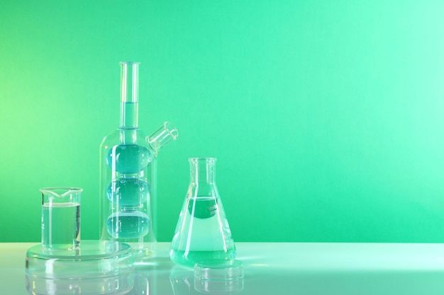 Analisi di laboratorio Diversi vetri sul tavolo contro uno sfondo verde spazio per il testo