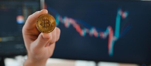 Analista investitore commerciante di criptovalute uomo d'affari in possesso di moneta bitcoin d'oro che acquista token di criptovaluta analizzando i rischi di investimento dei dati del mercato azionario