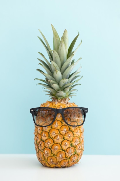 Ananas creativo con occhiali da sole isolati su sfondo colorato vacanze estive