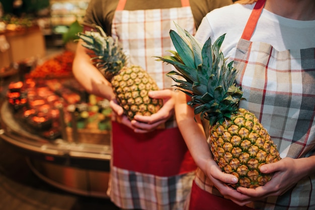 Ananas della holding della donna e del giovane in mani