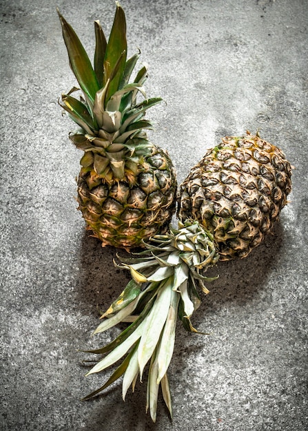 Ananas freschi maturi sul tavolo rustico.