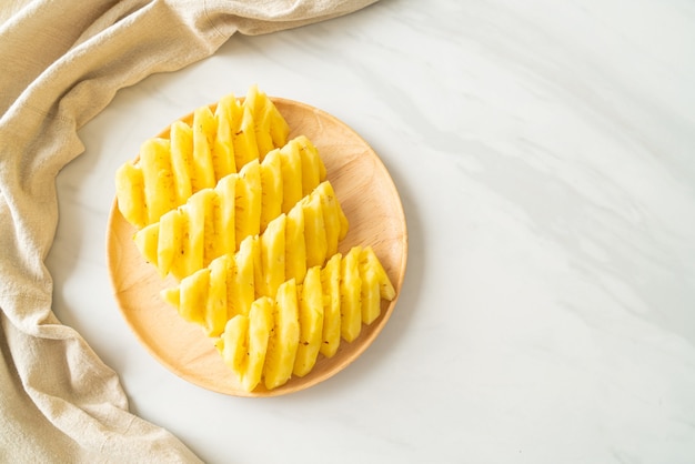 ananas fresco affettato su piatto di legno