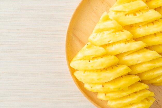 ananas fresco affettato su piatto di legno