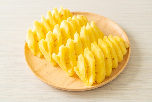 ananas fresco affettato su piatto di legno