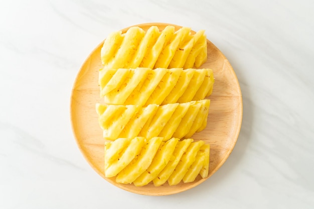 ananas fresco affettato sul piatto di legno