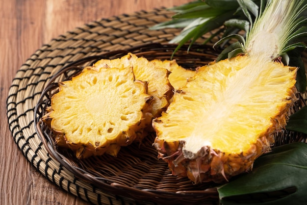 Ananas fresco tagliato su un vassoio sopra il fondo della tavola di legno scuro