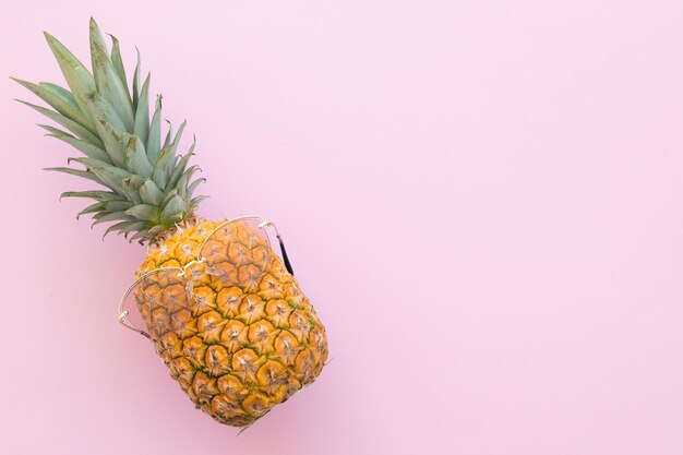 Ananas hipster con occhiali da sole alla moda su sfondo rosa Concetto estivo minimo