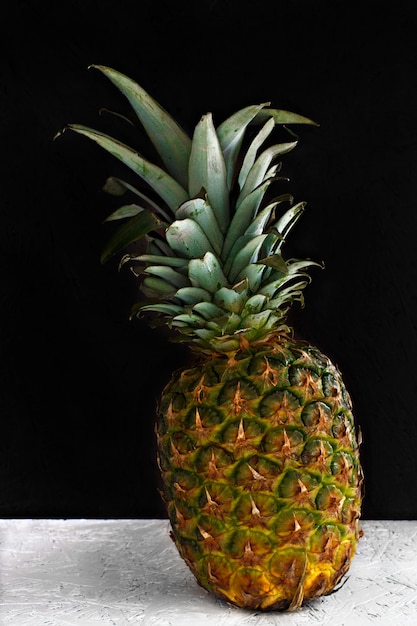 Ananas intero su fondo di legno bianco