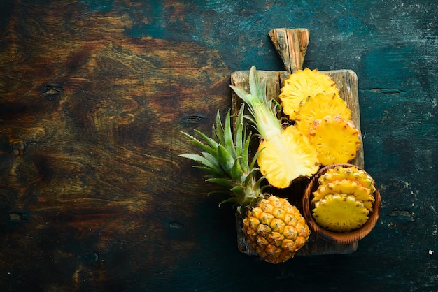 Ananas maturo affettato su uno sfondo di pietra nera Frutti tropicali Vista dall'alto Spazio libero per il testo