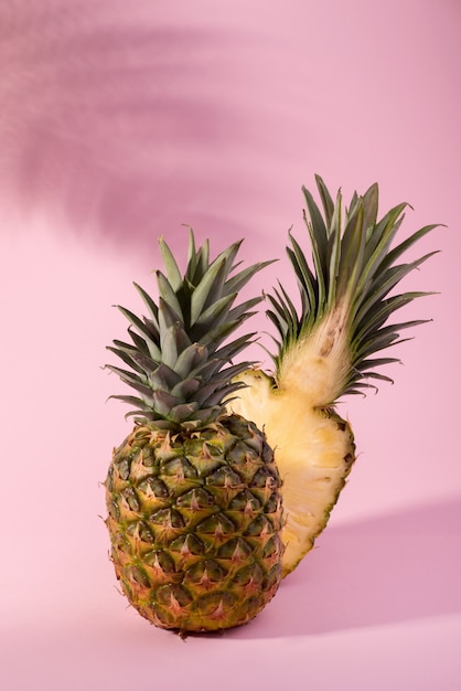 Ananas maturo fresco contro uno sfondo rosa. Ciao, banner concetto estivo.