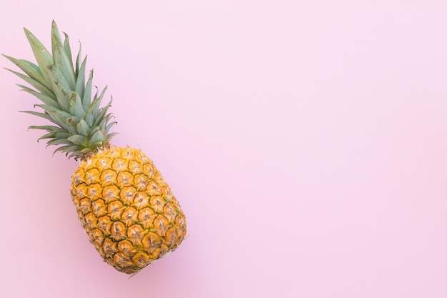 Ananas maturo su sfondo rosa