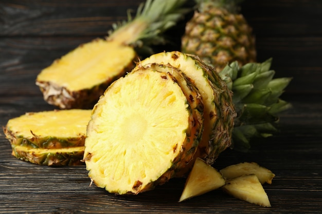 Ananas maturo tagliato su fondo di legno, fine in su