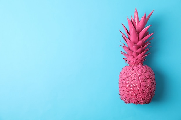 Ananas rosa dipinto su fondo blu, spazio per testo